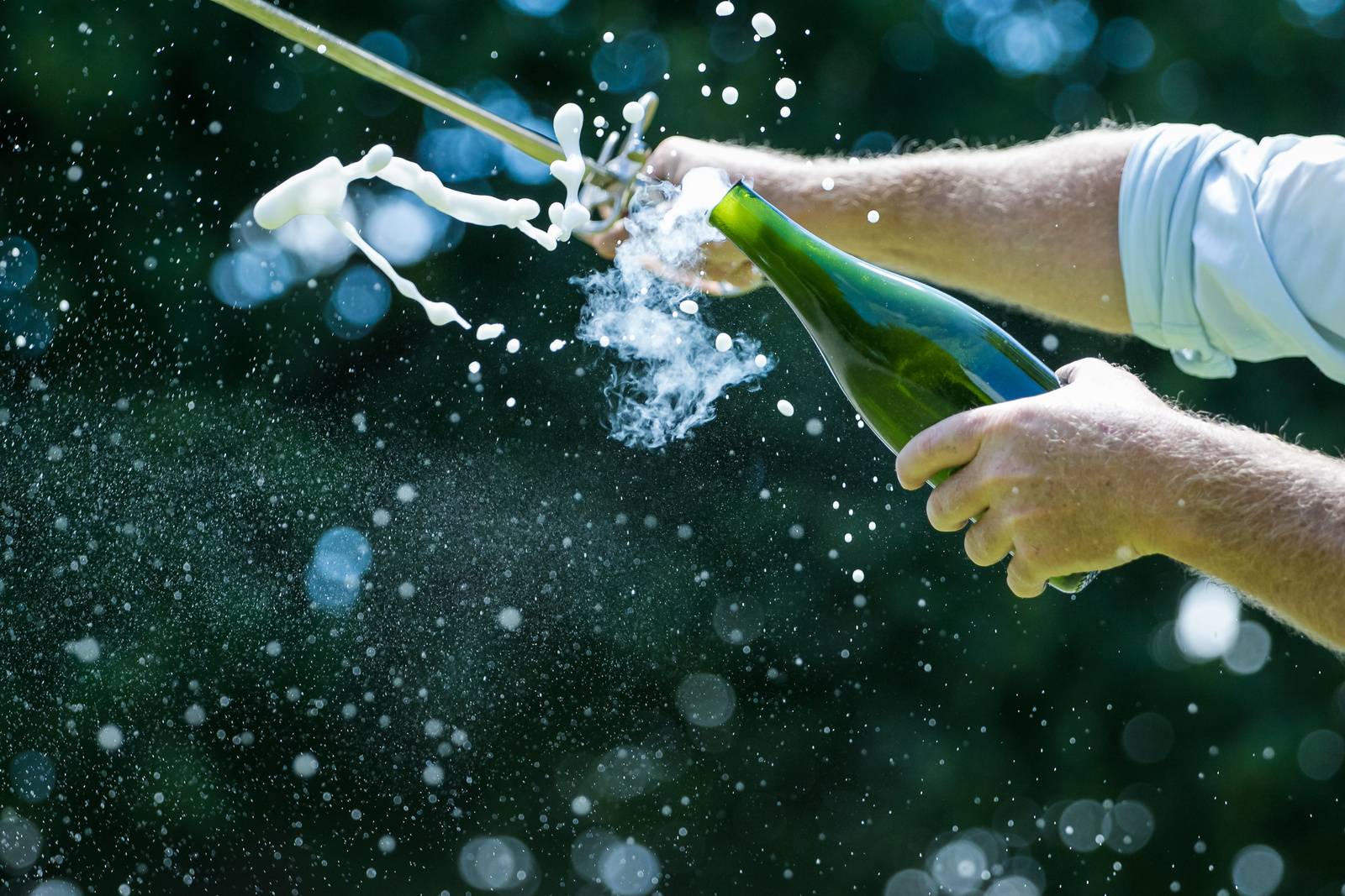 a person doing sabrage to champagne