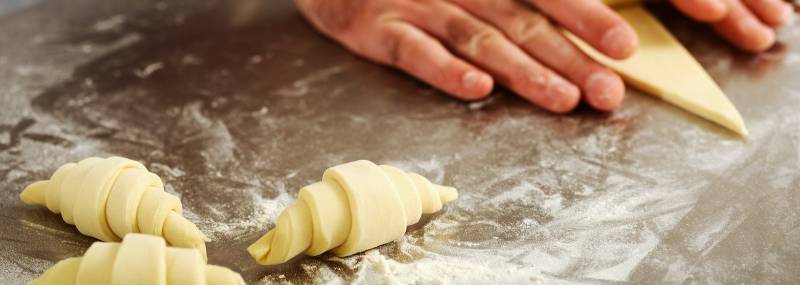 Hands preparing a croissant during a workshop Paris Croissant Baking Class