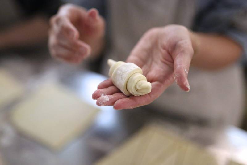 raw croissant on the hand during a Paris Croissant Baking Class by Deluxe France
