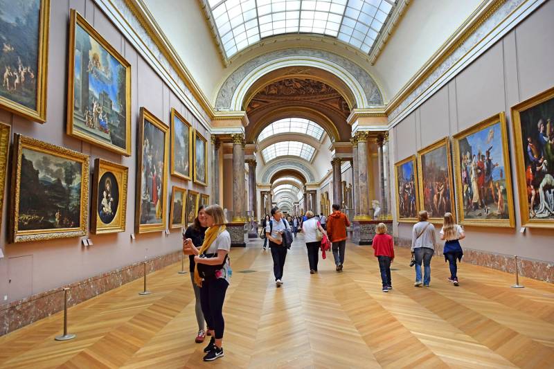 Louvre Museum Hall with tourists looking at the masterpieces