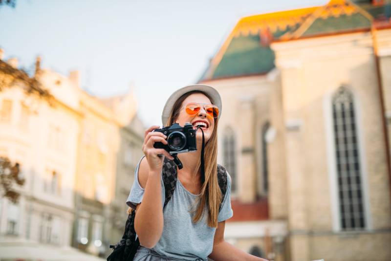 Young woman with a camera while touristing in the city