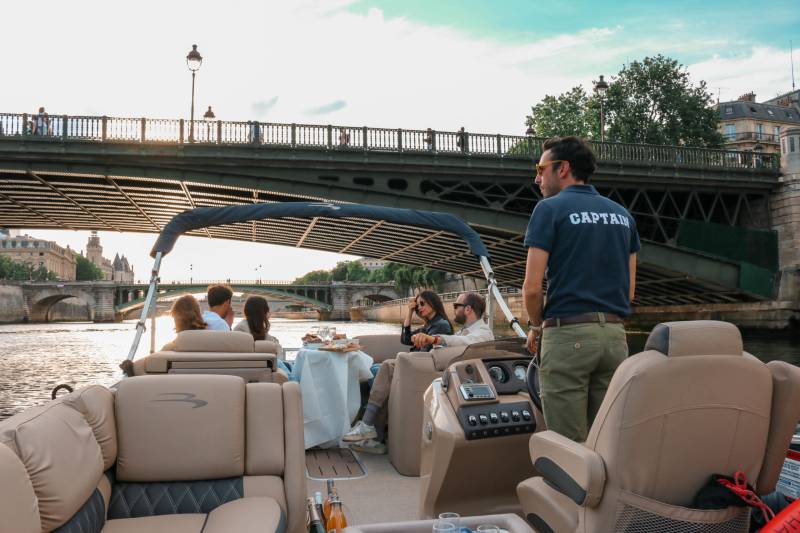 Captain and people on a pontoon boat at a Paris Seine River Private Cruise