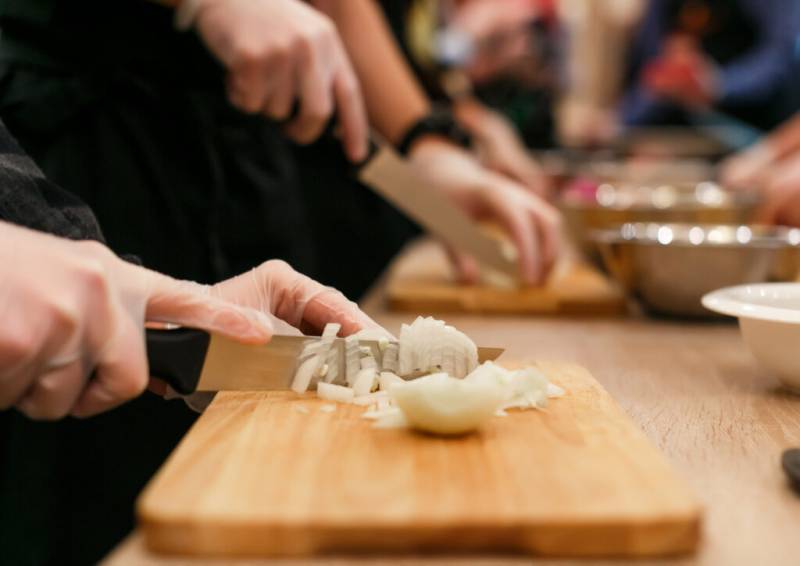 Woman cutting an onion during a Paris  Market Tour & Cooking Class